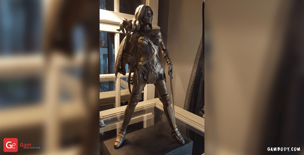 A detailed Wonder Woman statue in an action pose, with armor and shield, displayed on a stand.