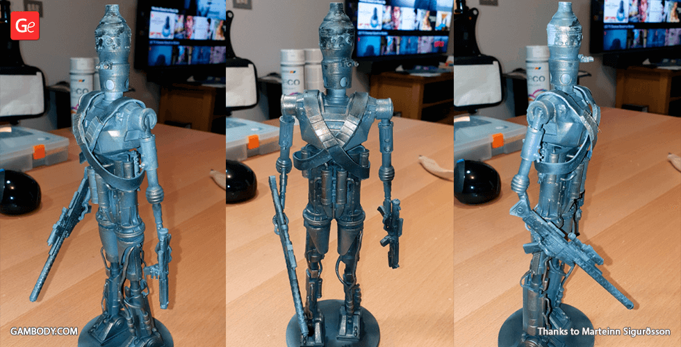 A 3D-printed model of a robotic droid, featuring armor and a weapon, displayed on a tabletop.